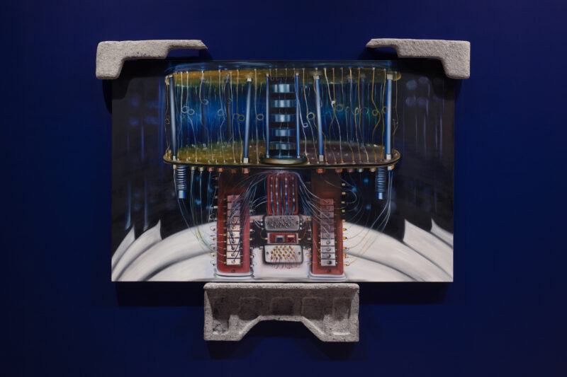 A painting features a complex mechanical structure with wires and components, mounted on a blue wall with concrete corner supports.