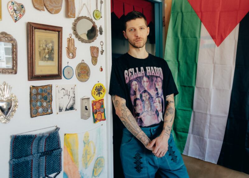 Jordan Nassar leaning against a wall in his studio.