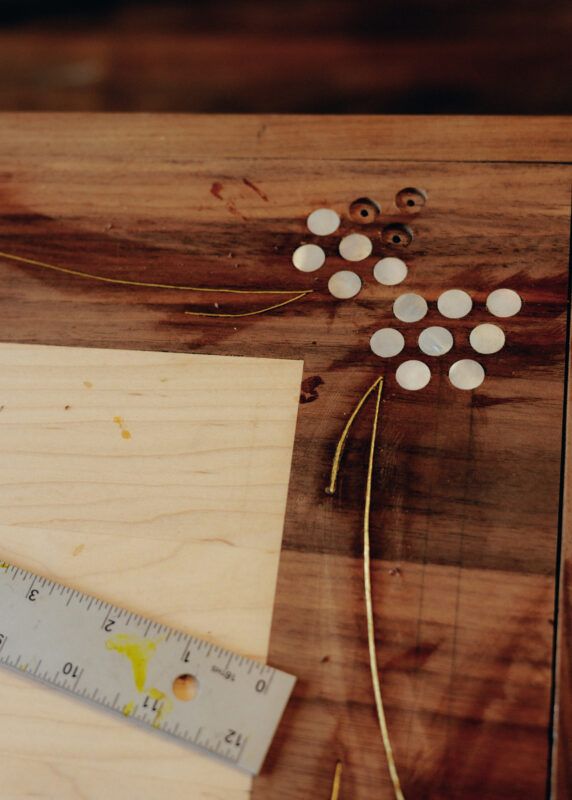 Close up of ruler lying on a wooden drawing board.